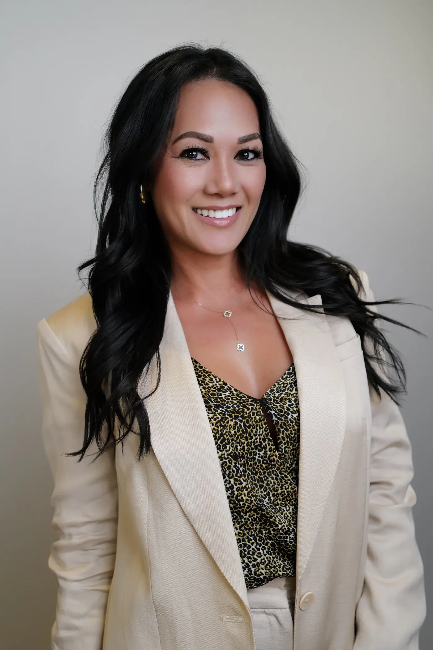 Professional event-style portrait of a woman in a light blazer