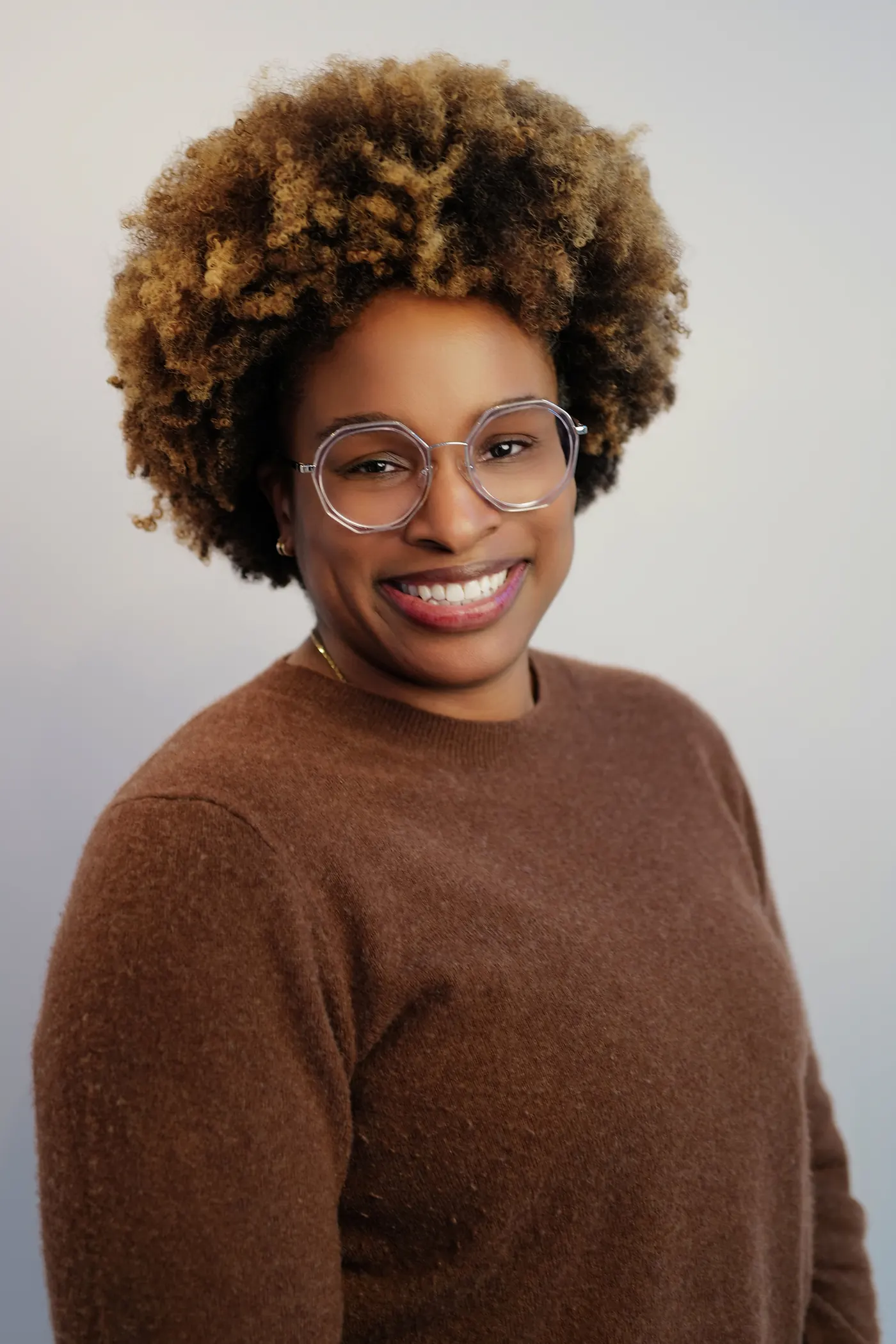 Warm studio portrait of a woman with natural curly hair